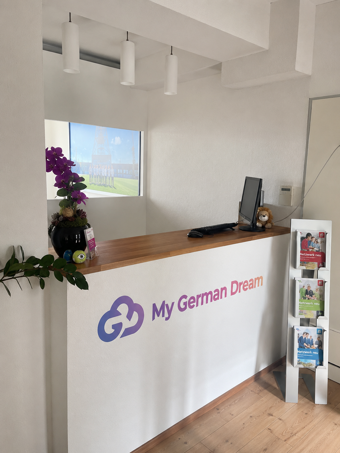 Reception desk at My German Dream Academy in Bochum, with the brand logo on the front panel and course brochures on display